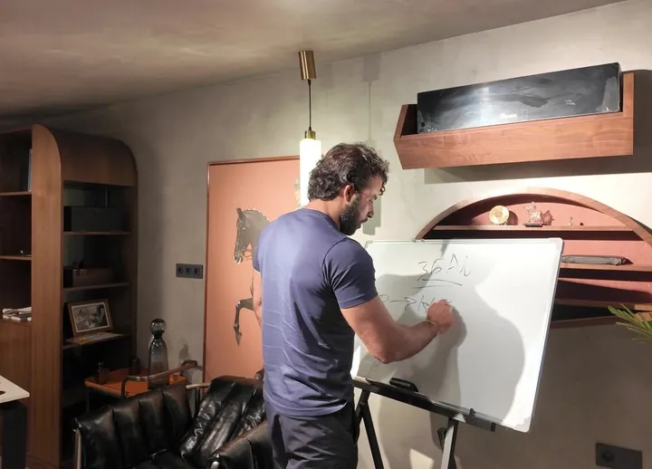 Yacine Dekkak écrit au tableau blanc.